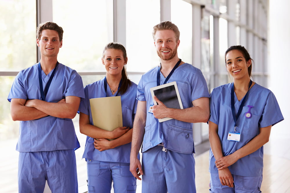 Group portrait of healthcare workers in hospital corridor