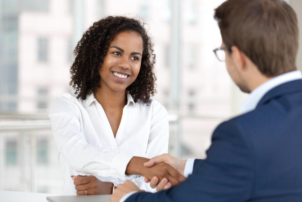 Smiling african female hr manager handshake hire male candidate